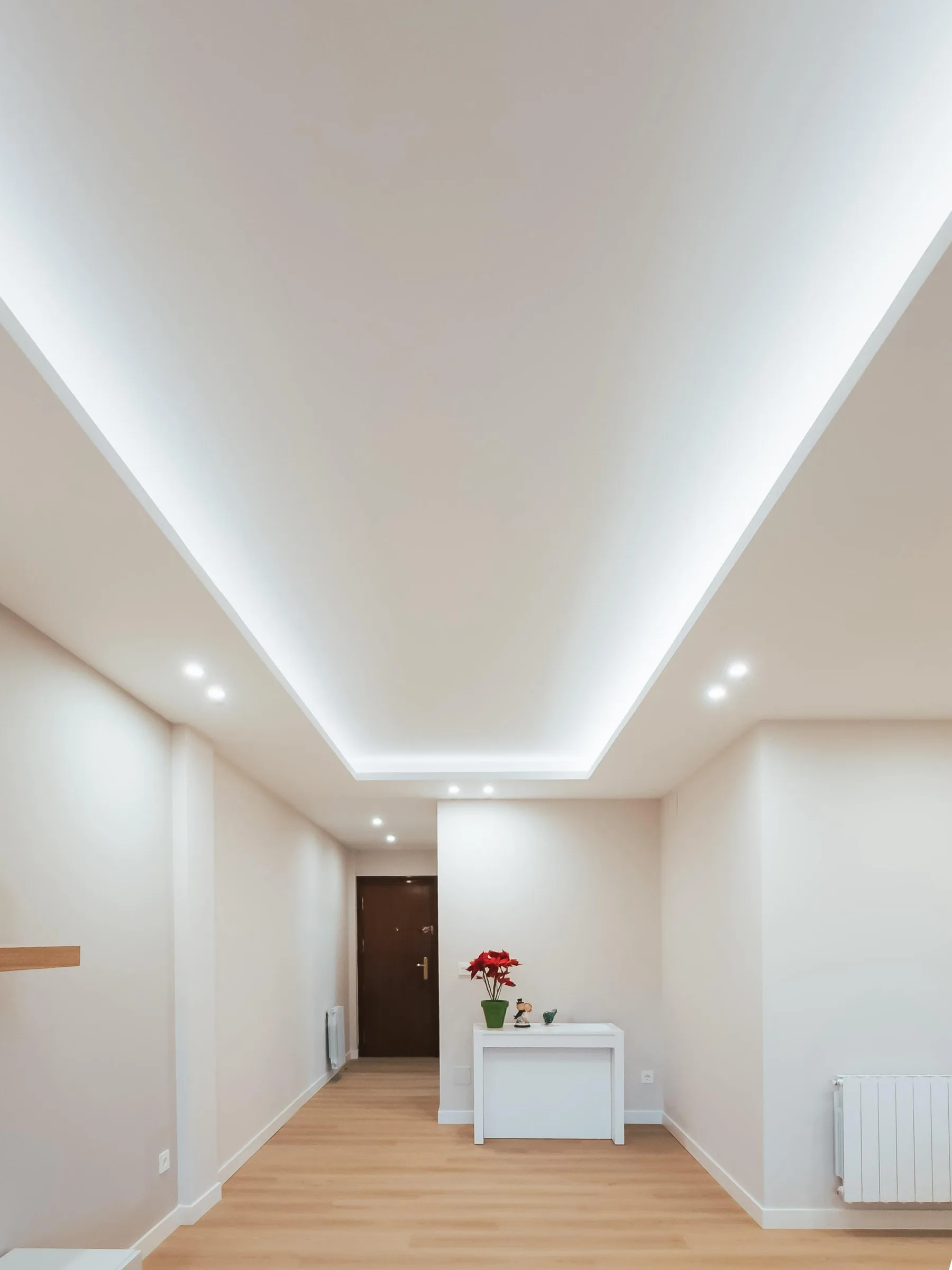 Reforma integral con falso techo iluminado y suelo de madera de Suiteak