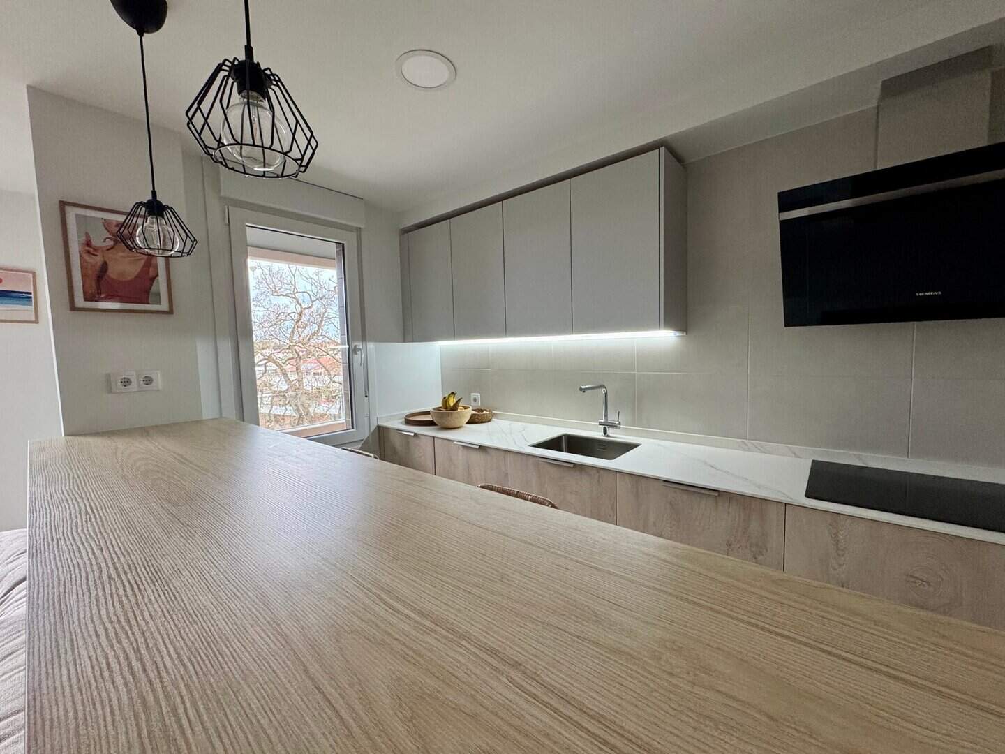 Cocina moderna con barra alta para desayunos - Imagen 1